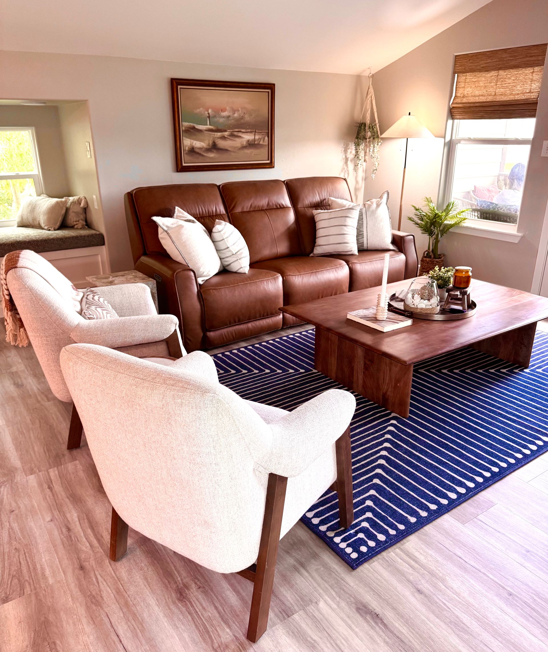 Living room with leather sofa, cream chairs and a navy patterned rug