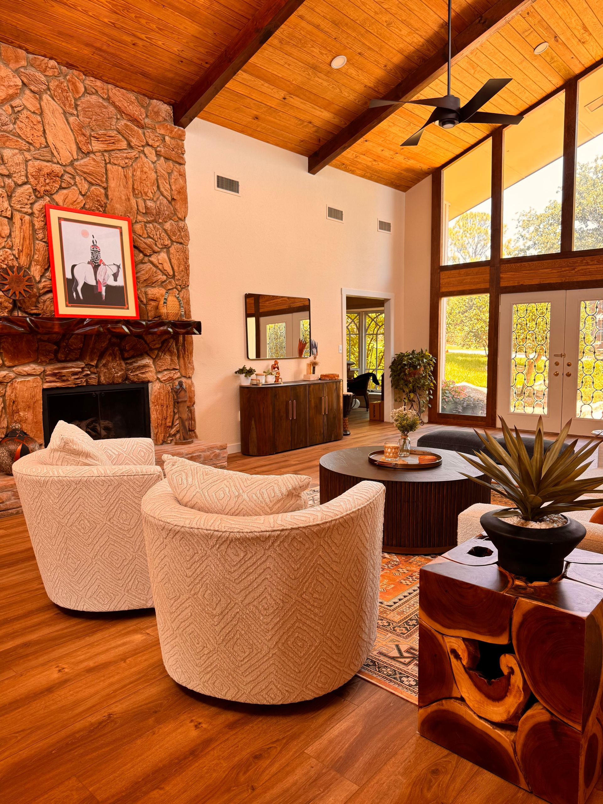 Vaulted living room with wood ceiling, stone fireplace and swivel chairs